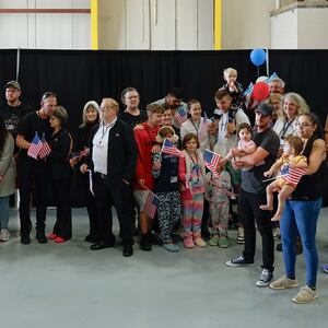 DULLES, VIRGINIA - MAY 12: Newly arrived South Africans wait to hear welcome statements from U.S. government officials in a hangar at Atlantic Aviation Dulles near Washington Dulles International Airport on May 12, 2025 in Dulles, Virginia. Dozens of white South Africans, also called Afrikaners, accepted an invitation from the Trump Administration to come to the United States as refugees. They say they are fleeing job discrimination and racial violence in their home country. Trump has halted virtually all refugee admissions for people fleeing famine and war but has created an expedited path into the U.S. for Afrikaners, descendants of white Europeans who created and led the brutal apartheid regime in South Africa from 1948 to 1994. (Photo by Chip Somodevilla/Getty Images)