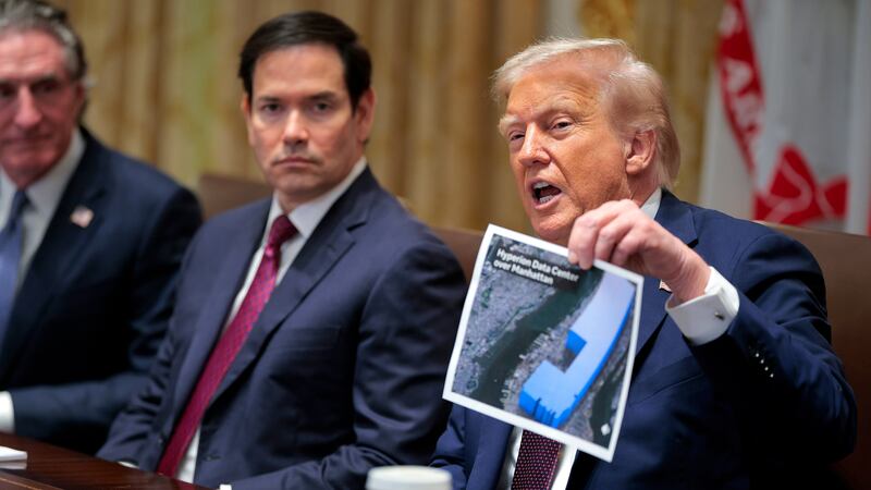 WASHINGTON, DC - AUGUST 26: U.S. President Donald Trump holds up a picture of a data center as he holds a cabinet meeting with members of his administration in the Cabinet Room of the White House on August 26, 2025 in Washington, DC. This is the seventh cabinet meeting of Trump's second term. Seated next to President Trump was Secretary of State Marco Rubio (C) and Interior Secretary Doug Burgum.