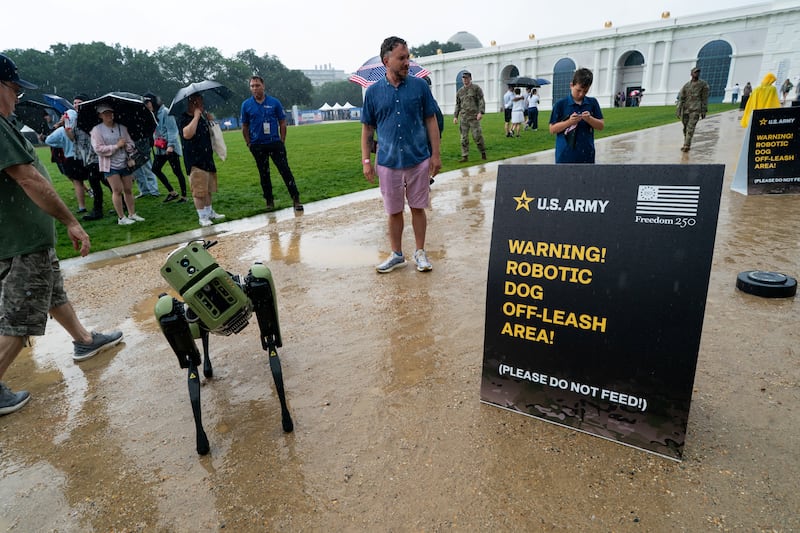 Visitors watch a U.S. Army Combat Capabilities Development Command (DEVCOM) robotic dog demonstration at The Great American State Fair in the rain on the National Mall in Washington, D.C., U.S., June 28, 2026.