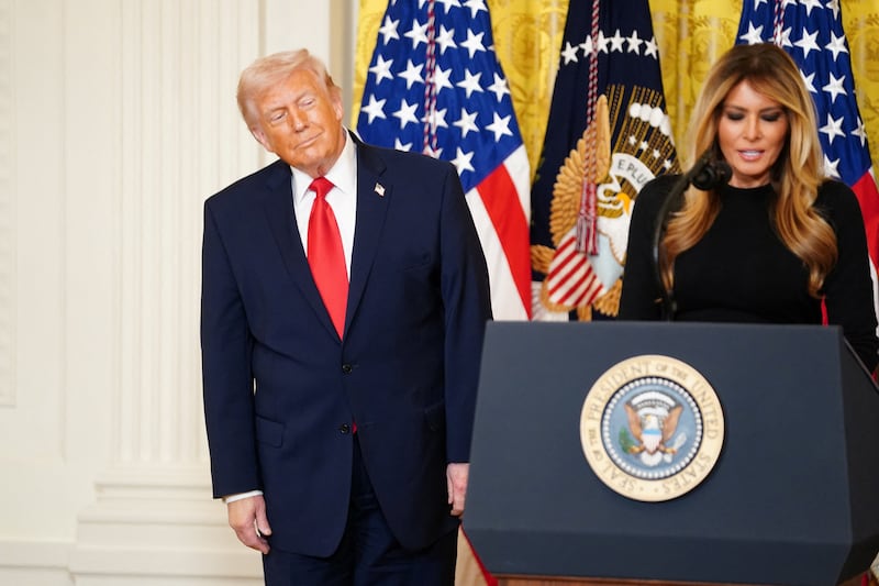 U.S. President Donald Trump listens as first lady Melania Trump speaks during a Women's History Month event, in the East Room of the White House in Washington, D.C., U.S. March 12, 2026.