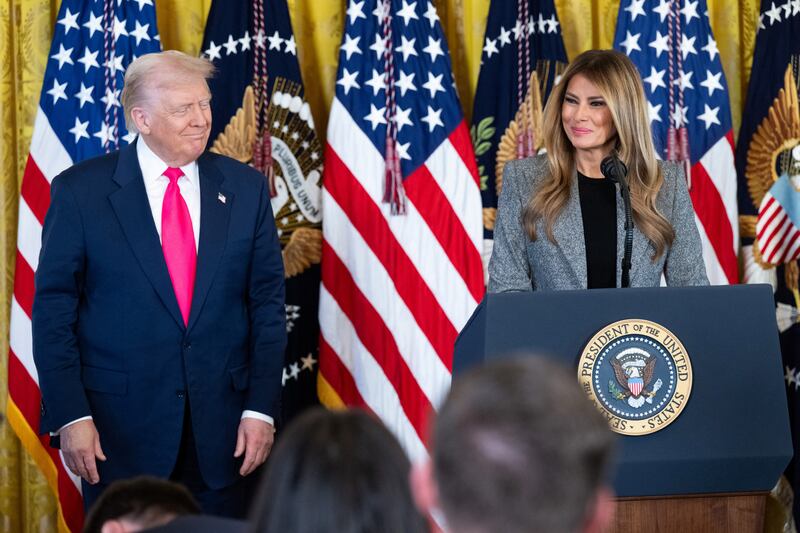 President Donald Trump's hand covered in makeup as he stands beside First Lady Melania Trump before signing an executive order on foster children and families in the East Room of the White House on November 13, 2025.