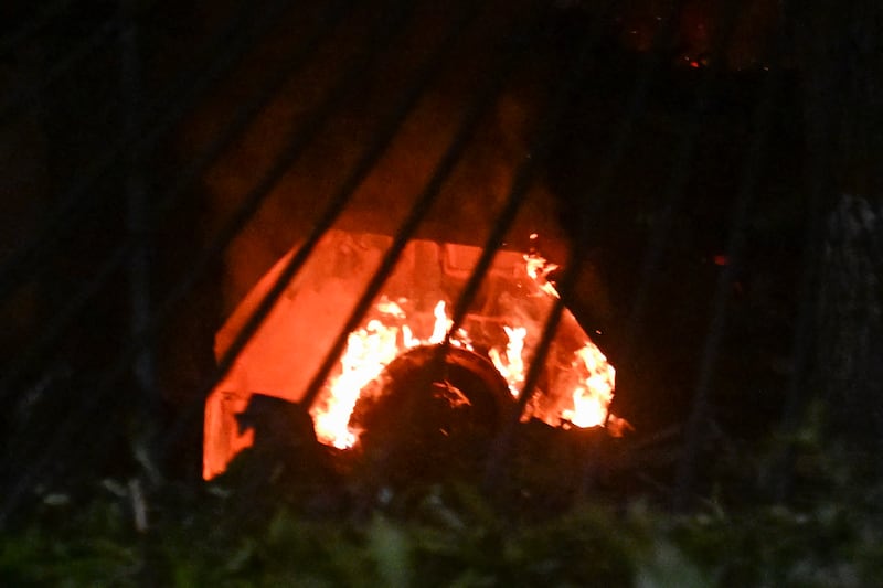 A vehicle burns at La Carlota air base in Caracas after a series of explosions on January 3, 2026. Loud explosions, accompanied by sounds resembling aircraft flyovers, were heard in Caracas around 2:00 am (0600 GMT) on January 3, an AFP journalist reported. The explosions come as US President Donald Trump, who has deployed a navy task force to the Caribbean, raised the possibility of ground strikes against Venezuela. (Photo by Juan BARRETO / AFP via Getty Images)