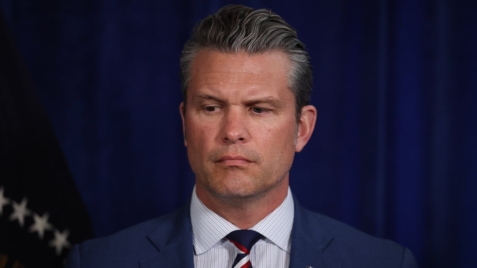 PALM BEACH, FLORIDA - JANUARY 03: U.S. Secretary of War Pete Hegseth listens as U.S. President Donald Trump addresses the media during a news conference at his Mar-a-Lago club on January 03, 2026, in Palm Beach, Florida. President Trump confirmed that the U.S. military carried out a large-scale strike in Caracas overnight, resulting in the capture of Venezuelan leader Nicolas Maduro and his wife, Cilia Flores. (Photo by Joe Raedle/Getty Images)