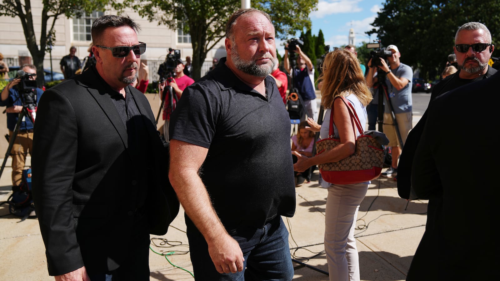 InfoWars founder Alex Jones walks outside Waterbury Superior Court during his trial in 2022.
