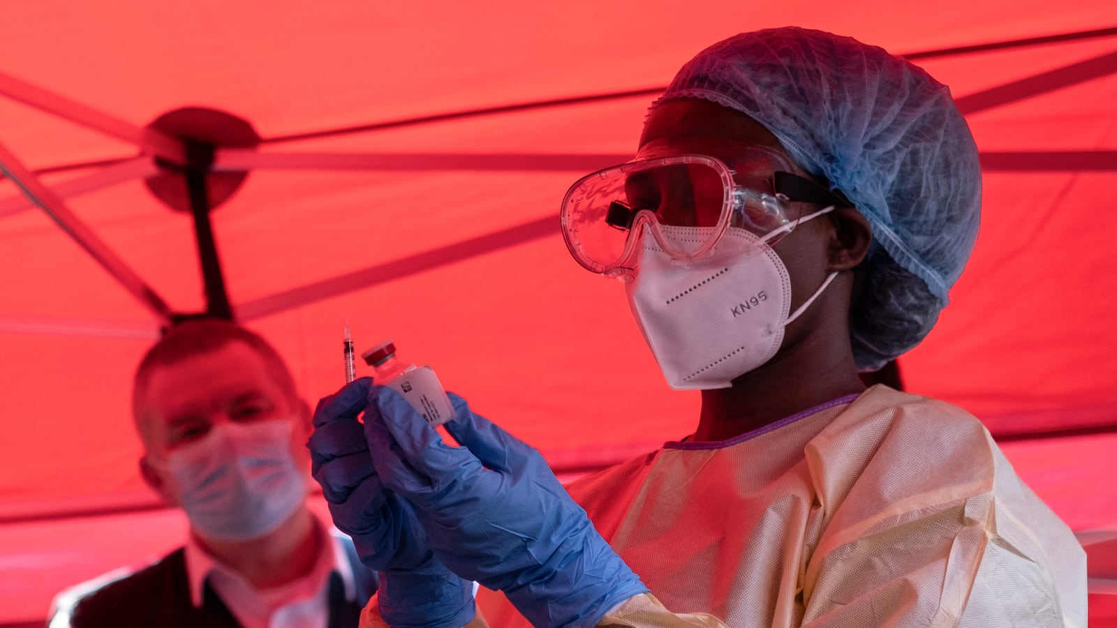 TOPSHOT - A nurse wears protective medical clothing and prepares a syringe by drawing a dose from a vaccine vial during the launch of an Ebola trial vaccination campaign at Mulago Referral Hospital in Kampala on February 3, 2025. Uganda started an Ebola Sudan virus vaccination trial on February 3, 2024, four days after an outbreak was confirmed, the WHO announced, beginning with those deemed at highest risk of the disease. (Photo by Badru Katumba / AFP) (Photo by BADRU KATUMBA/AFP via Getty Images)