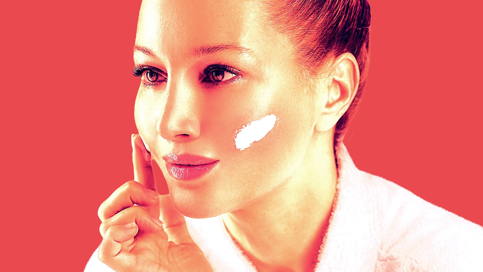 A woman applies a cleaning balm on her cheeks.