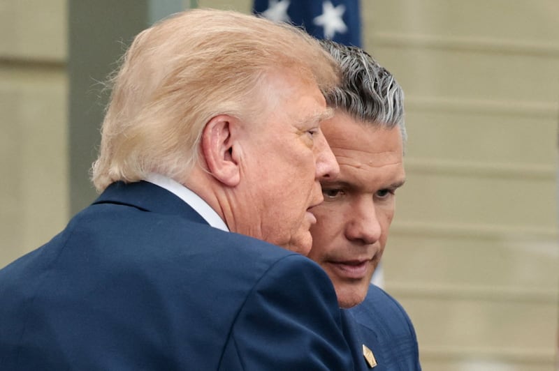 Donald Trump and Pete Hegseth huddle during an observance ceremony marking the 25th anniversary of the 9/11 attack on the Pentagon.