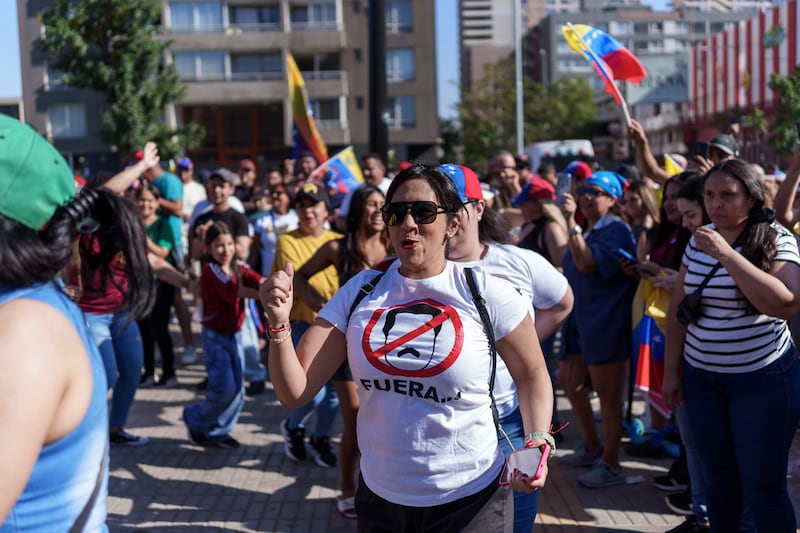 Venezuelan citizens in Chile celebrate outside the Parque Almagro Metro station during a rally after the confirmation of Nicolas Maduro's capture