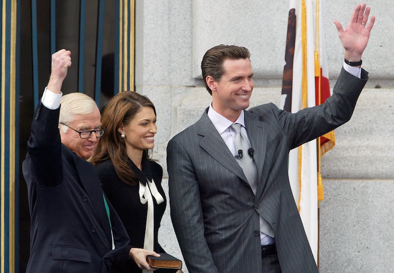 The new Mayor of San Francisco Gavin Newsom joins his father Judge William Newsom and his wife Kimberly Guilfoyle Newsom in waving to the crowd after taking the oath of office. Michael Macor/ The Chronicle on 1/8/04 ALSO RAN 12/26/04 The work begins: Mayor Gavin Newsom waves to the crowd after taking the oath of office. Ran on: 12-26-2004 Mayor Gavin Newsom struck the right tone in his inaugural speech stressing the need to find solutions to the city's ills. (Photo By Michael Macor/The San Francisco Chronicle via Getty Images)