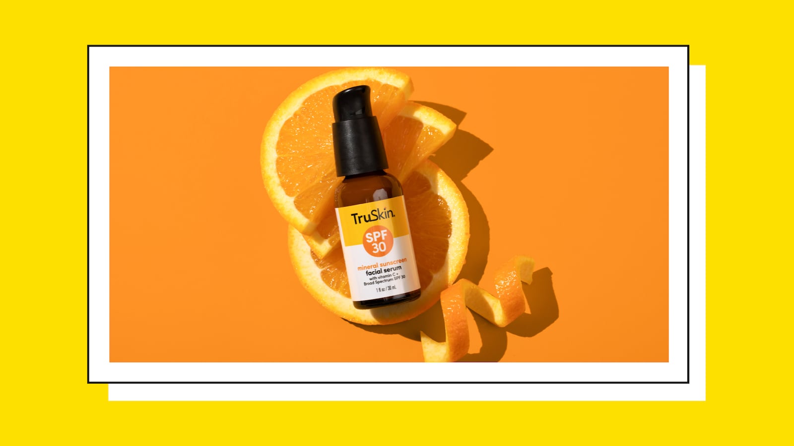 TruSkin's new SPF Serum lying on top of a few slices of an orange. Next to it is part of the orange peel.