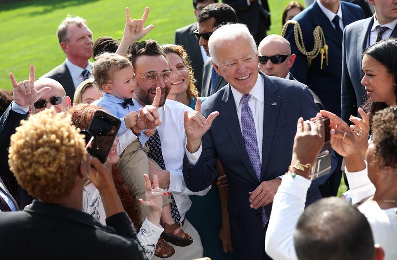 U.S. President Joe Biden signs "I love you," in American sign language as he greets advocates and members of the disabled community following an event honoring the Americans with Disabilities Act (ADA) and Rehabilitation Act (Rehab Act), at the White House on October 02, 2023.