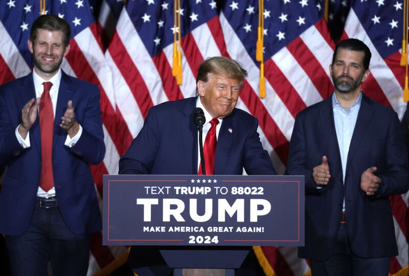 Former President Donald Trump speaks at his caucus night event, with sons Eric Trump and Donald Trump Jr. looking on, at the Iowa Events Center on January 15, 2024 in Des Moines, Iowa.
