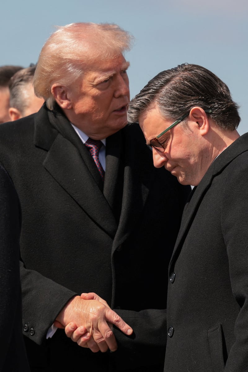 U.S. President Donald Trump shakes hands with House Speaker Mike Johnson (R-LA), at Dover Air Force Base in Dover, Delaware, U.S., March 18, 2026. REUTERS/Kylie Cooper