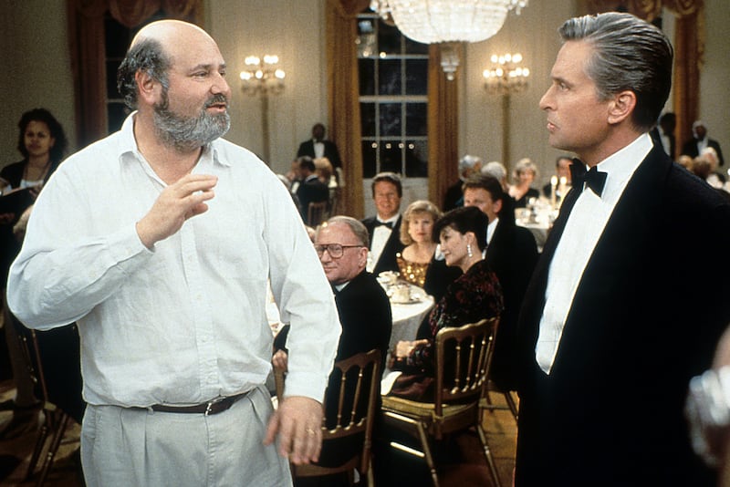 Michael Douglas listening to Director Rob Reiner in between scenes from the film 'The American President', 1995.