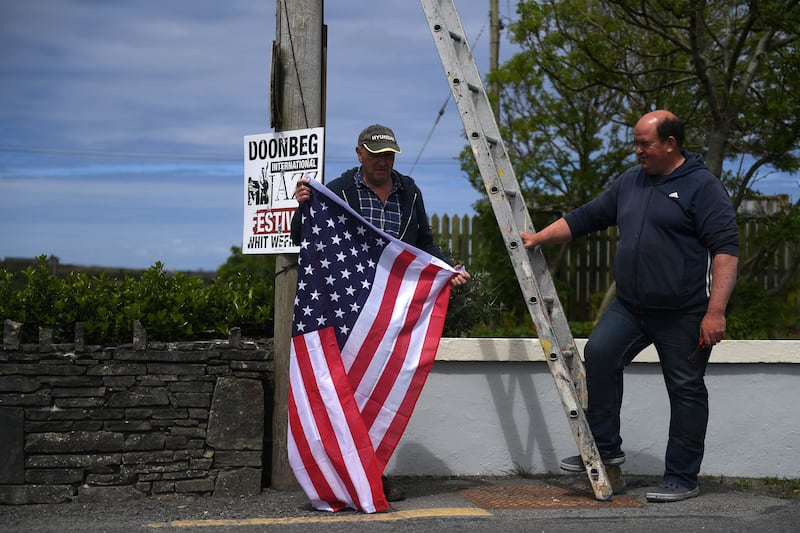 Tommy Haugh and Danny Buckley carry a ladder and a U.S. flag to festoon the streets of Doonbeg village ahead of a visit by U.S. President Donald Trump to his golf course in the County Clare village of Doonbeg, Ireland, May 28, 2019. Picture taken May 28, 2019. REUTERS/Clodagh Kilcoyne