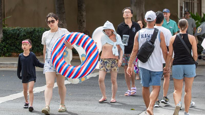 People depart from a beach in Oahu, Hawaii.