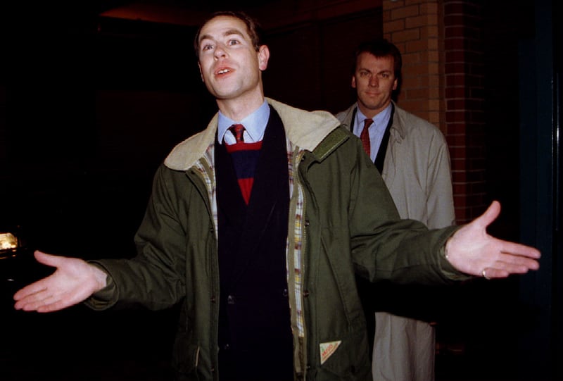 Prince Edward speaks to waiting photographers and reporters upon leaving his central London television production company office December 20. . Behind him is a detective
