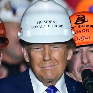 Members of "Steelworkers for Trump" pose with former US President and Republican presidential candidate Donald Trump after they gifted him a hard hat during a campaign rally at Arnold Palmer Regional Airport in Latrobe, Pennsylvania, October 19, 2024. (Photo by Jim WATSON / AFP) (Photo by JIM WATSON/AFP via Getty Images)