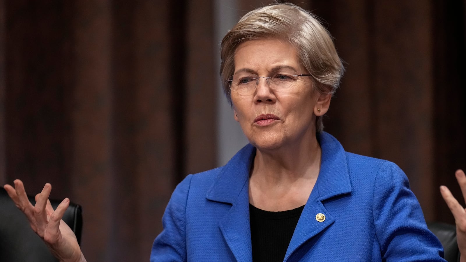 Sen. Elizabeth Warren (D-MA) speaks to a staff member before the start of a Senate Banking Committee hearing on oversight of credit reporting agencies, on Capitol Hill April 27, 2023 in Washington, DC.
