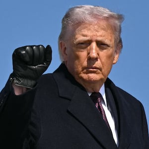 U.S. President Donald Trump pumps his fist as he boards Air Force One at Joint Base Andrews in Maryland before departing for Texas on February 27, 2026.
