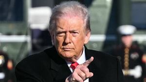 US President Donald Trump gestures as he walks to board Air Force One at Joint Base Andrews, Maryland on January 13, 2026.