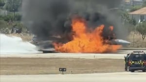 The Hellenic Air Force F-16 ablaze on the runway at Zakynthos International Airport as emergency teams battle the flames.