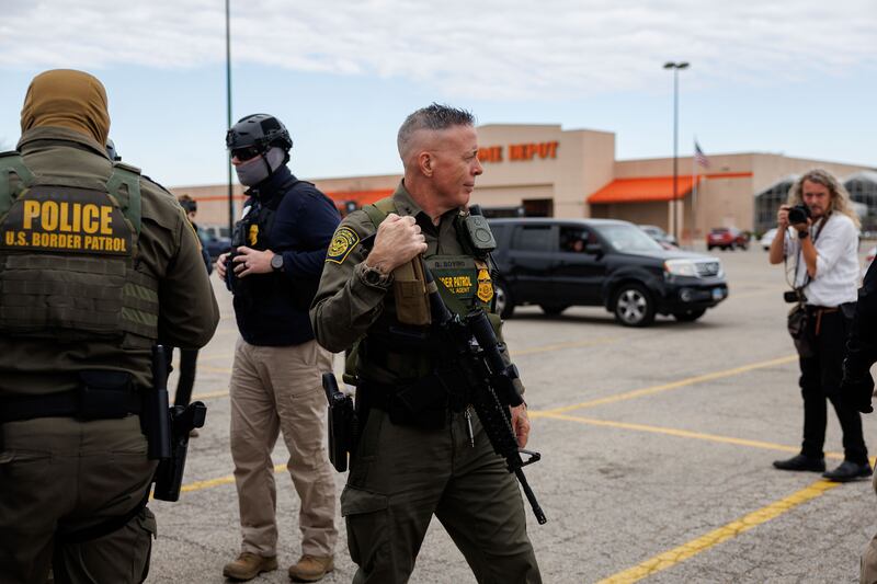 Border Patrol Cmdr. Gregory Bovino walks with other border patrol officers while conducting immigration enforcement actions near a Home Depot parking lot