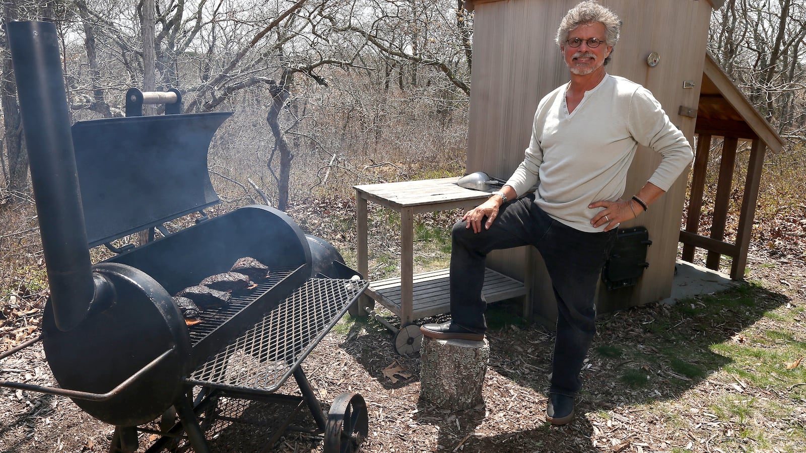 Steven Raichlen poses while cooking Oak smoked big bad beef ribs