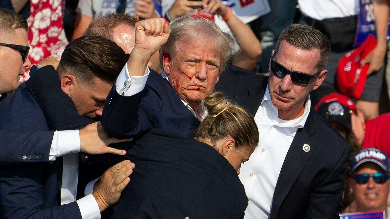 Donald Trump is seen with blood on his face surrounded by Secret Service agents as he is taken off the stage at a campaign event at Butler Farm Show Inc. in Butler, Pennsylvania, July 13, 2024.