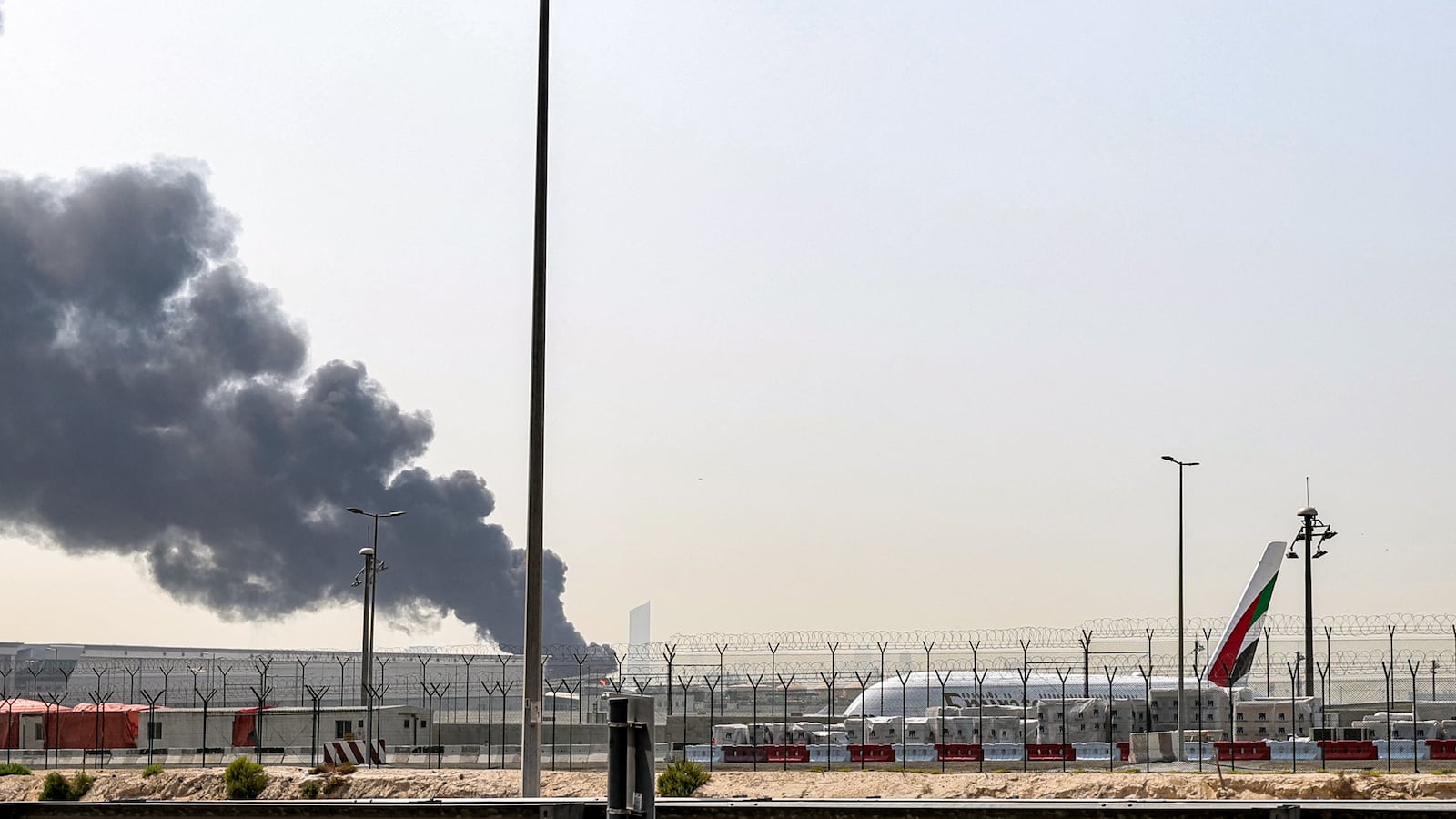 A smoke plume rises from an ongoing fire near Dubai International Airport in Dubai on March 16, 2026.