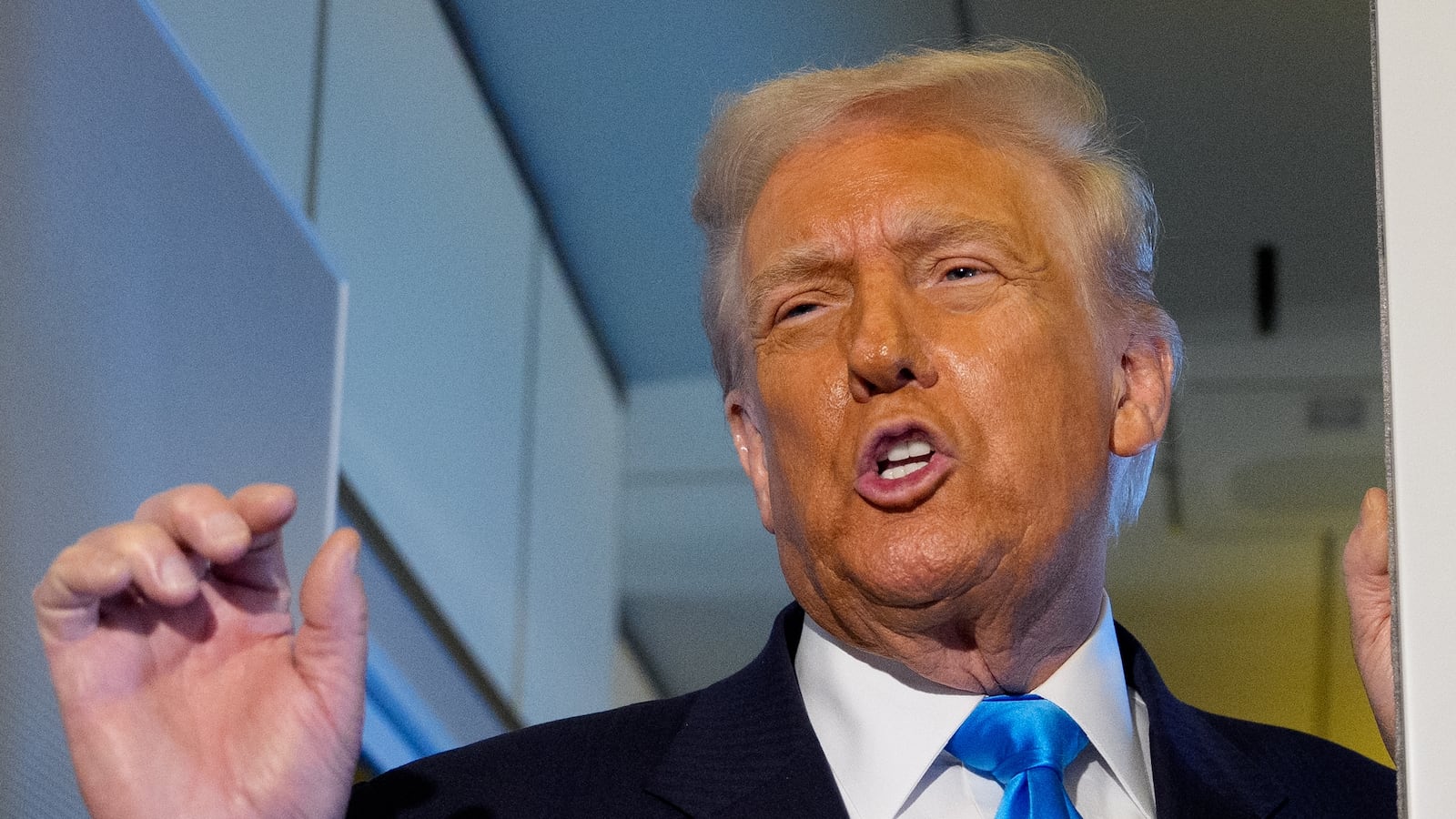 U.S. President Donald Trump speaks to journalists aboard Air Force One