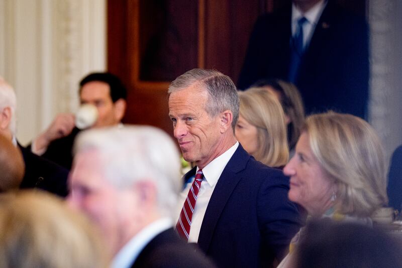 Senate Majority Leader John Thune listening to President Donald Trump give remarks during a breakfast at the White House where the president urged Republican senators to end the filibuster on November 5, 2025.