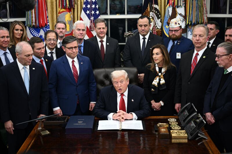 US President Donald Trump (C) speaks while signing the bill package to re-open the federal government in the Oval Office of the White House in Washington, DC, on November 12, 2025. Congress on Wednesday ended the longest government shutdown in US history, 43 days that paralyzed Washington and left hundreds of thousands of workers unpaid while Republicans and Democrats played a high-stakes blame game. The Republican-led House of Representatives voted largely along party lines to approve a Senate-passed package that will reopen federal departments and agencies, as many Democrats fume over what they see as a capitulation by party leaders. (Photo by Brendan SMIALOWSKI / AFP) (Photo by BRENDAN SMIALOWSKI/AFP via Getty Images)