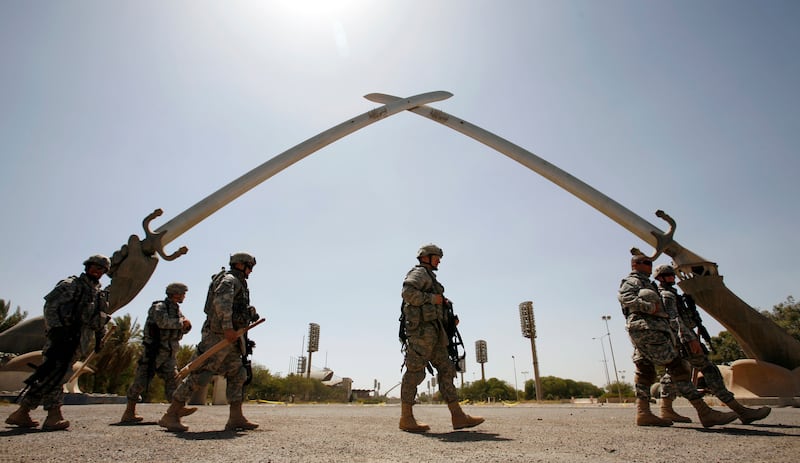 U.S. soldiers walk by the Swords of Qadisiyah monument in the Green Zone during a patrol in Baghdad July 13, 2007. REUTERS/Nikola Solic (IRAQ)