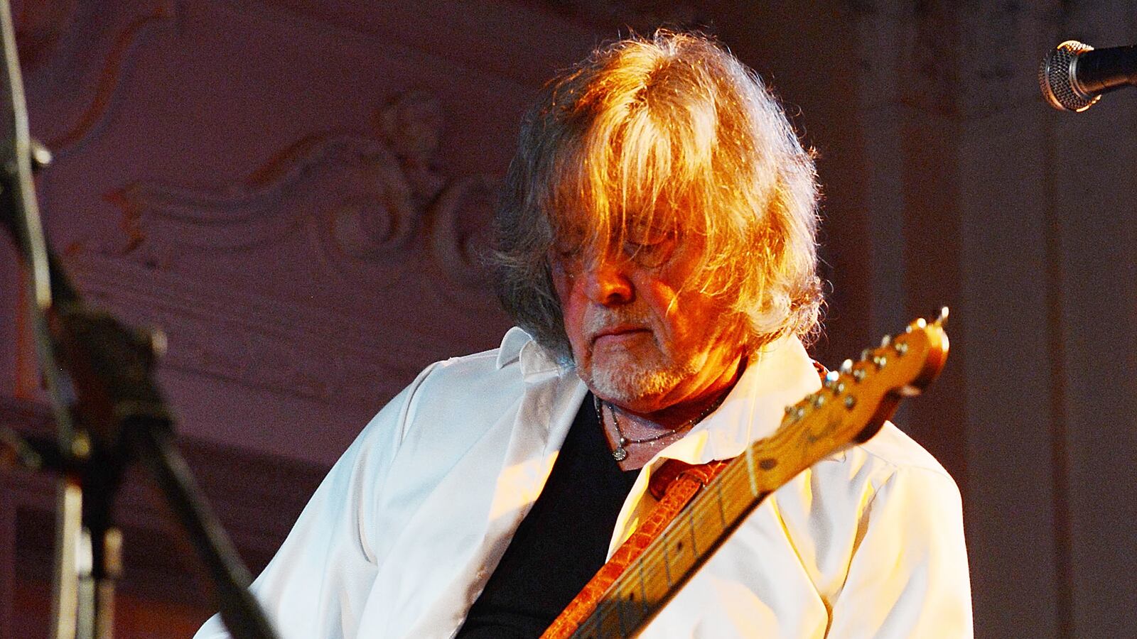 Guitarist Anthony 'Top' Topham strums his guitar.