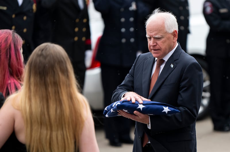 Minnesota Gov. Tim Walz presents an American flag to the family of DFL Rep. Melissa Hortman and her husband Mark Hortman