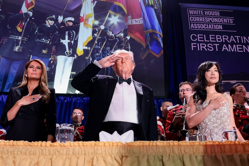 President Donald Trump, with first lady Melania Trump and CBS News senior White House correspondent Weijia Jiang, salutes during the annual White House Correspondents' Association dinner in Washington, D.C., U.S., April 25, 2026.