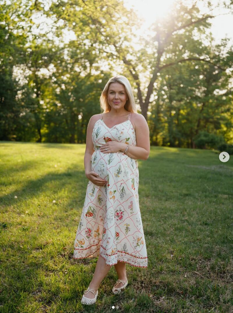 Karoline Leavitt poses holding her baby bump.