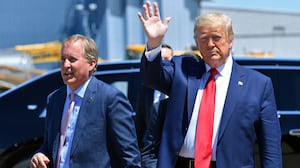 President Donald Trump waves upon arrival, alongside Attorney General of Texas Ken Paxton (L) in Dallas, Texas, on June 11, 2020.