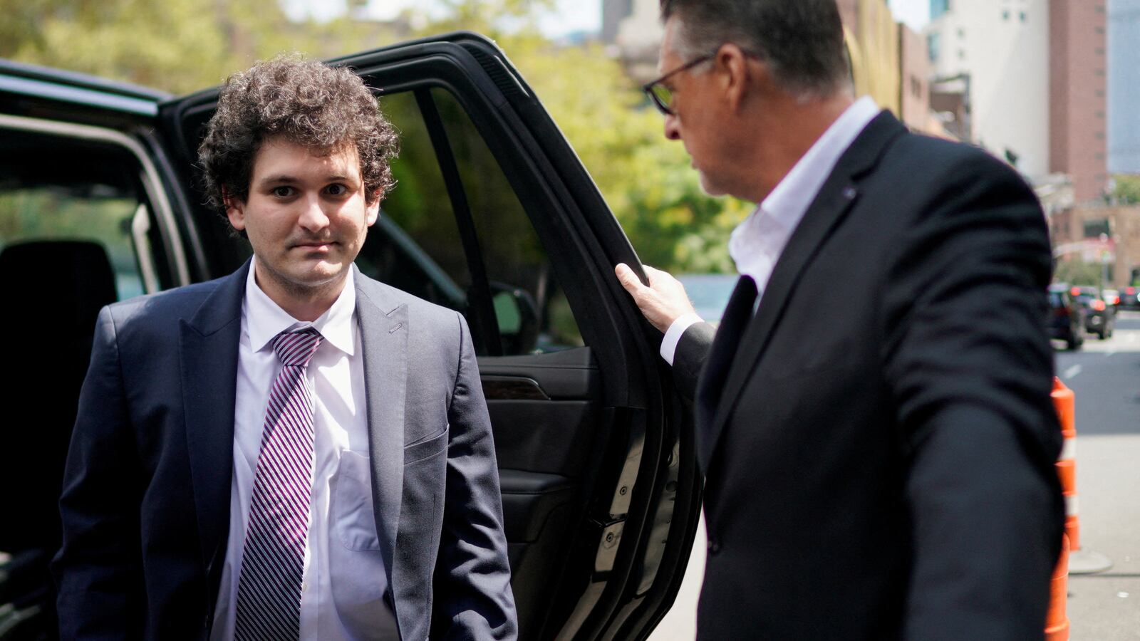 Sam Bankman-Fried exits a vehicle on his way into court.