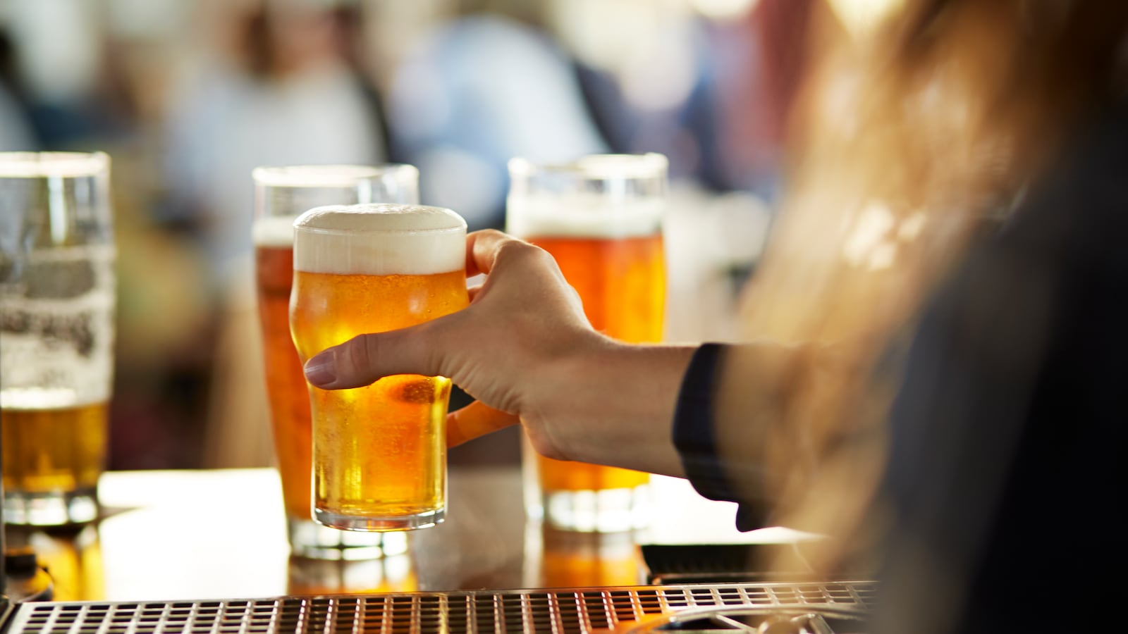 A bartender serves beers at a bar.