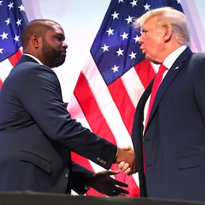 Rep. Byron Donalds (R-FL) shakes hands with  former U.S. President Donald Trump