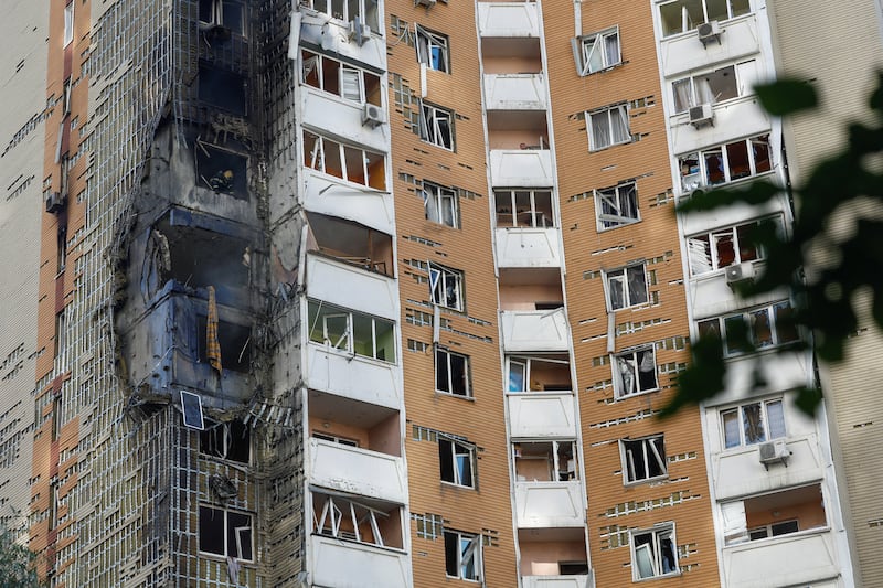 A police officer guards as bodies of residents covered with thermal blanket lie on the ground at a site of a Russian missile strike, amid Russia's attack on Ukraine, in Kyiv, Ukraine September 8, 2026. REUTERS/Stringer