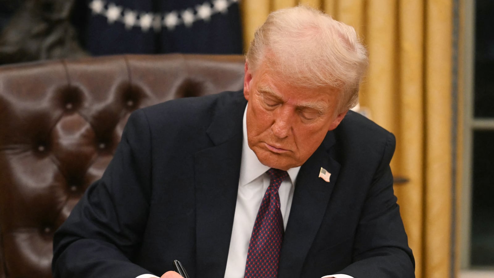 US President Donald Trump signs an executive order in the Oval Office of the WHite House in Washington, DC, on January 20, 2025. (Photo by Jim WATSON / POOL / AFP) (Photo by JIM WATSON/POOL/AFP via Getty Images)