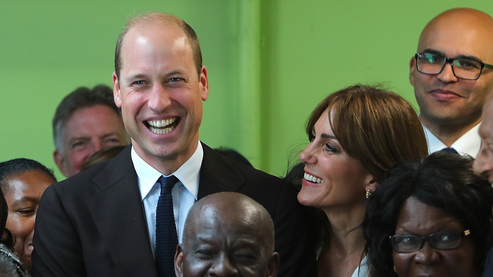 Prince William, Prince of Wales and Catherine, Princess of Wales laugh with members from the Windrush Cymru Elders