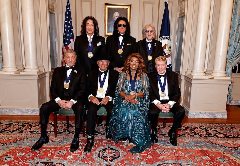 WASHINGTON, DC - DECEMBER 06: Honorees (Back Row L-R) Paul Stanley, Gene Simmons, Peter Criss of KISS and (Front Row L-R) Sylvester Stallone, George Strait, Gloria Gaynor, Michael Crawford pose for the class photo at the 48th Kennedy Center Honors Medallion Reception at the U.S. Department of State on December 06, 2025 in Washington, DC. (Photo by Paul Morigi/Getty Images)