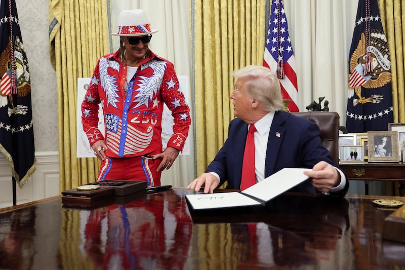 U.S. President Donald Trump speaks with Kid Rock after signing an executive order related to the U.S. live entertainment ticketing industry in the Oval Office at the White House in Washington, D.C., March 31, 2025.   REUTERS/Leah Millis