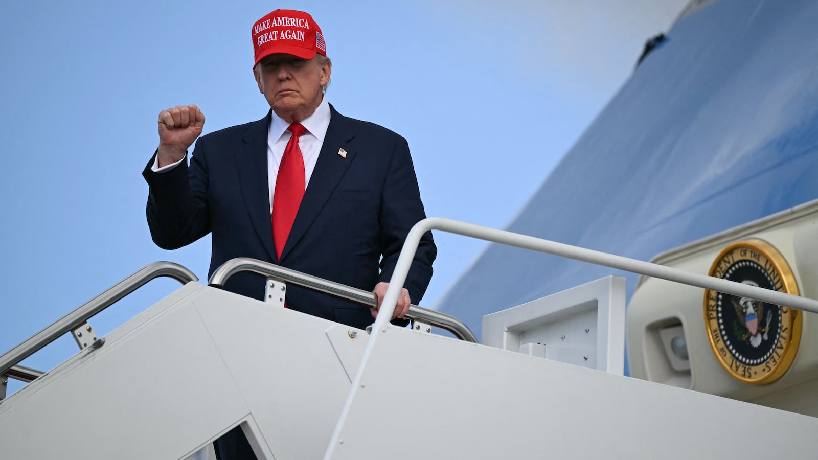 President Donald Trump gestures to the press as he steps off Air Force One upon arrival at Joint Base Andrews in Maryland on October 30, 2025, following his trip to Asia in recent days.