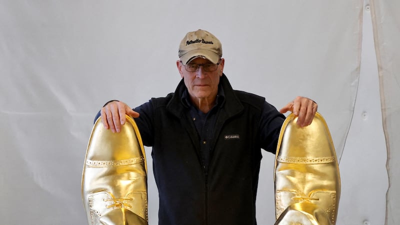 Sculptor Alan Cottrill, 73, examines his gold-leafed bronze statue of Donald Trump at his studio in Zanesville, Ohio.