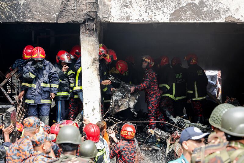Bangladesh's fire service and other officials search and rescue operation as they clear the remains of an Air Force training jet that crashed into a school in Dhaka on July 21, 2025. At least 16 people, mostly students, were killed on July 21, when a training aircraft of the Bangladesh Air Force crashed into a school campus in the capital Dhaka, the government said. (Photo by Abdul Goni / AFP) (Photo by ABDUL GONI/AFP via Getty Images)